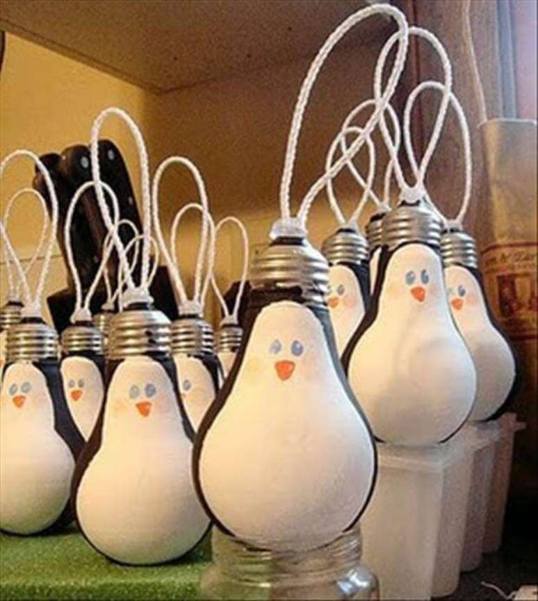 27- Pinguim de lâmpada é uma fofa de reaproveitar esse material e decorar a sua casa para o Natal