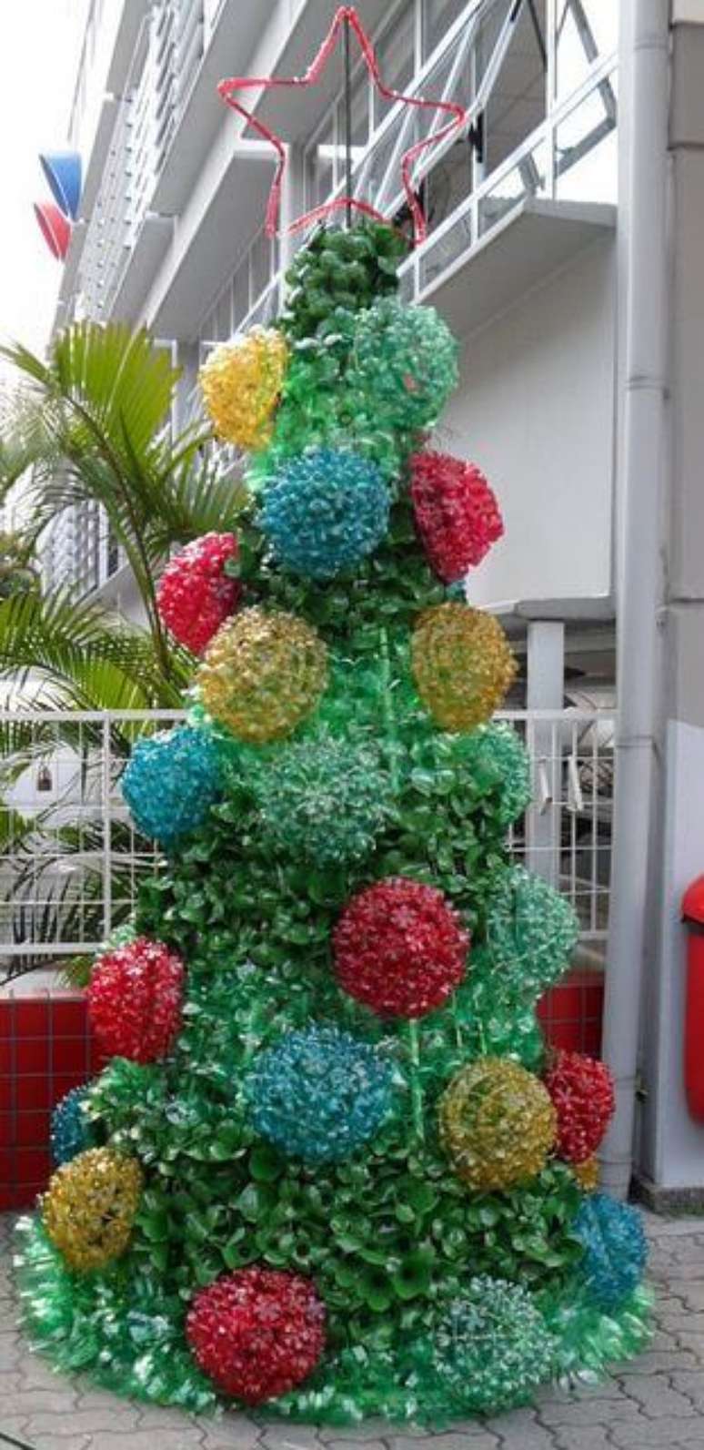 57. Árvore de natal de garrafa PET verde com enfeites grandes coloridos. Foto de Photography InStyle