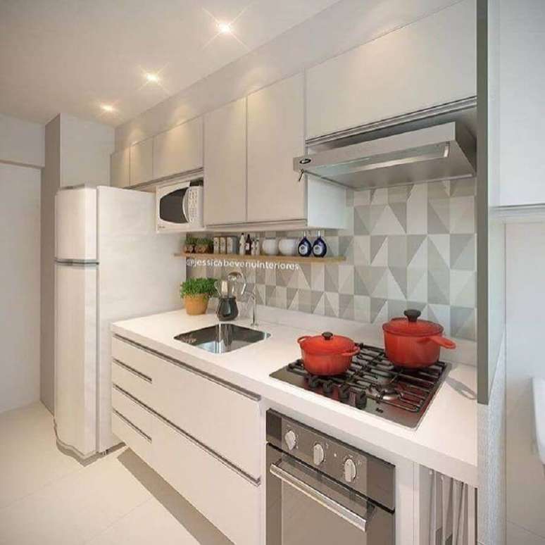 25. Decoração simples para cozinha planejada pequena com armários brancos – Foto: Jessica Bevenu Interiores