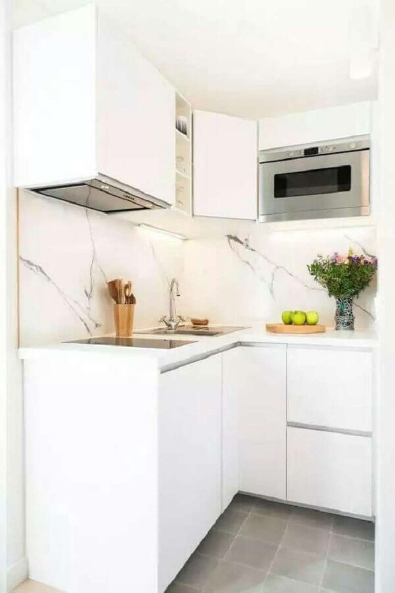 43. A parede revestida com pedra deixou a cozinha planejada pequena mais sofisticada &ndash; Foto: Cuisine Jardin