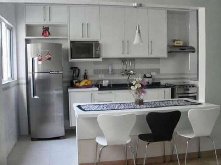 83. Decoração simples com armários brancos e um pendente branco para cozinha planejada pequena com balcão – Foto: Pinterest
