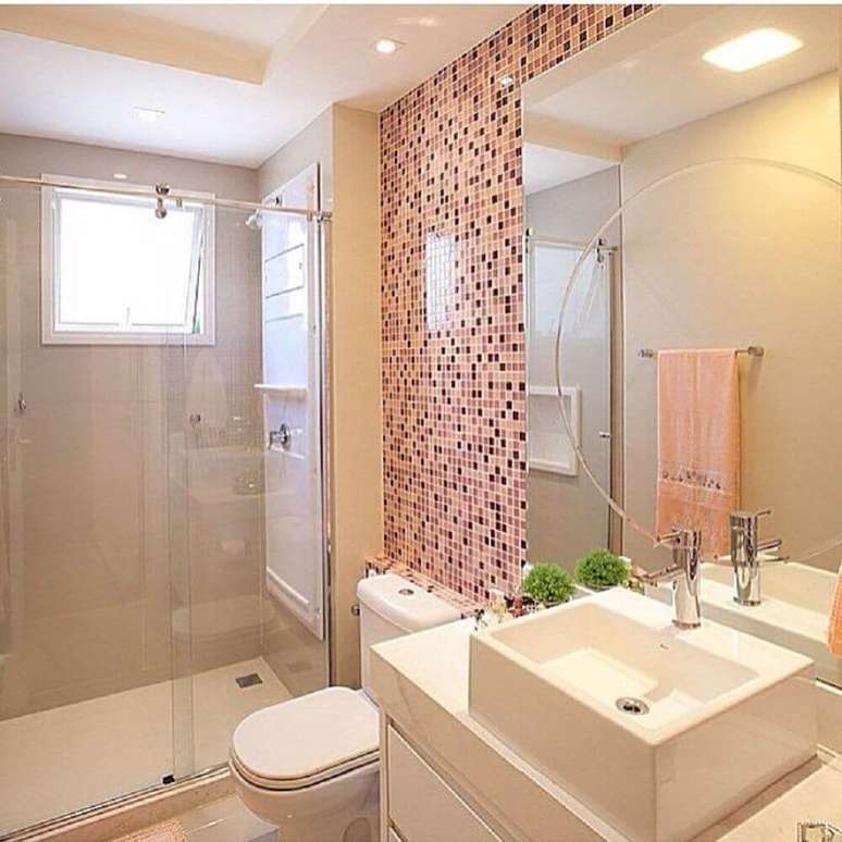 29. Decoração clean para banheiro com pastilha de vidro em tons de rosa e box de vidro – Foto: Stalktr