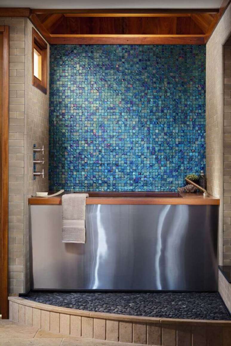 35. A decoração do banheiro com pastilha azul ganhou um toque arrojando com o destalhes em madeira e a banheira em inox – Foto: Pinterest