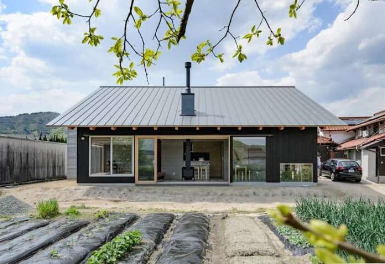 21. Casa pré-fabricada de madeira preta com telhado cinza