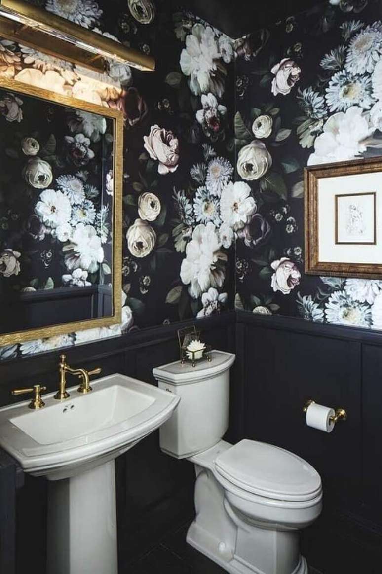 13. Decoração de banheiro preto e branco com detalhes em dourado e papel de parede com flores brancas e fundo escuro – Foto: Decoration Maison