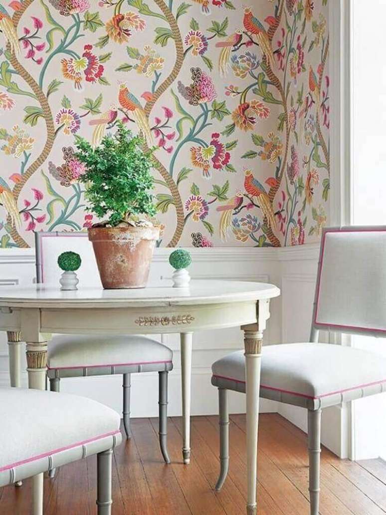 1. Decoração delicada para sala de jantar com mesa branca redonda e papel de parede com flores coloridas – Foto: Jutarnji List