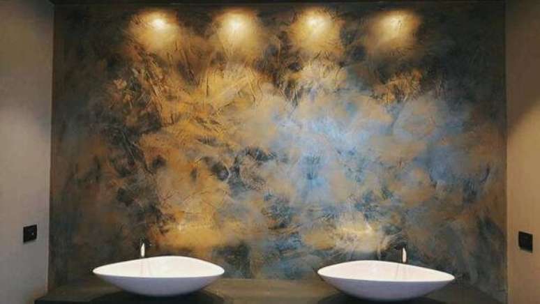 30- A parede com textura de marmorato atrás das pias foi valorizada pela iluminação. Fonte: Torra Tintas