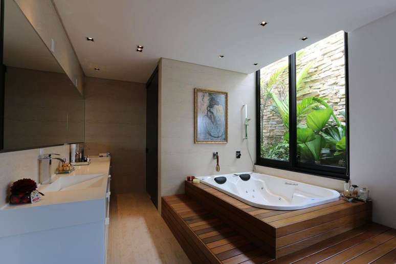 2. Sala de banho com banheira dupla com jatos de água e revestimento de deck de madeira. Projeto por Zaav Arquiteura