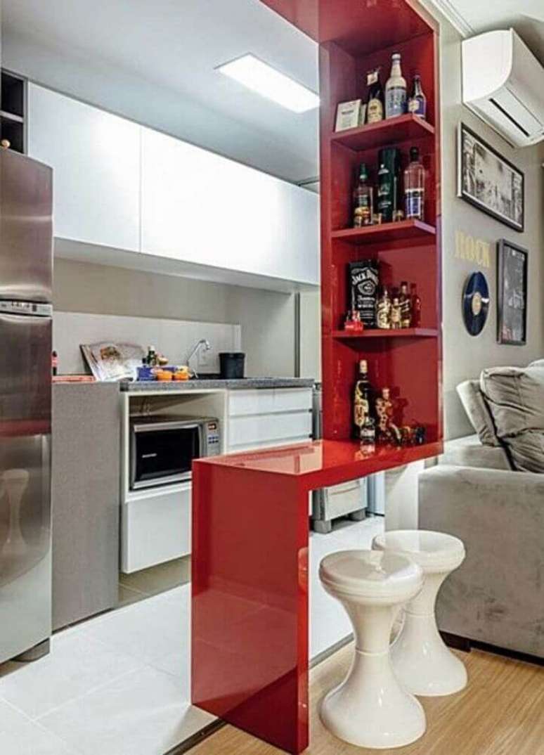 53. Decoração simples para cozinha americana com sala de estar com bancada e nichos vermelhos – Foto: Zozu