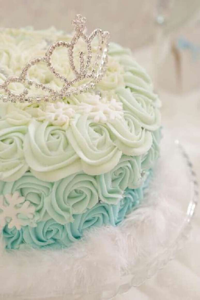 8- O bolo da mesa principal da festa Frozen ideias decorativas tem o chantilly tingido em três tons de verde. Fonte: Aprendendo a ser mãe