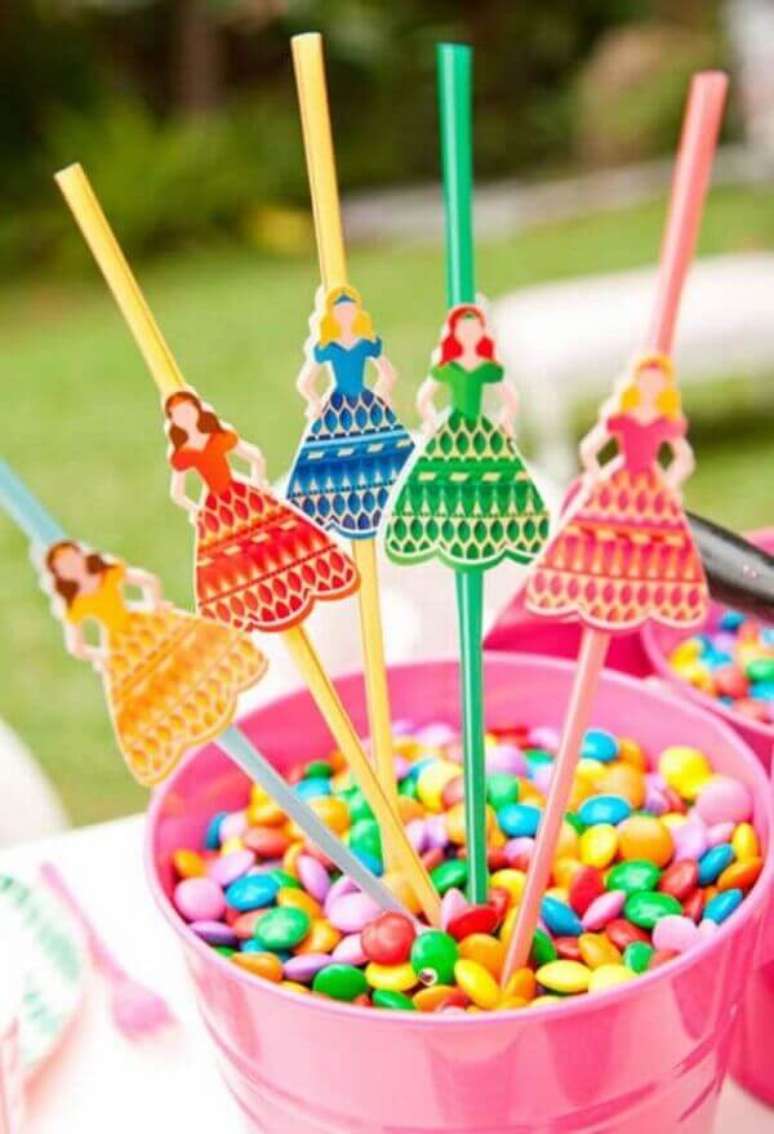 21- As ideias criativas para a festa das princesas t&ecirc;m copinhos de confeitos coloridos enfeitado com as personagens. Fonte: Casa e Festa