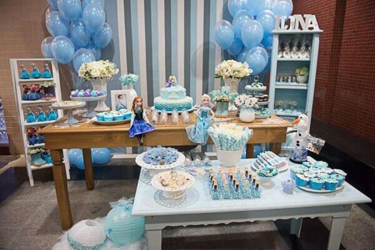 45- Na festa frozen ideias criativas o azul está presente nas mesas, balões e painel. Fonte: Moms Inspire Blog