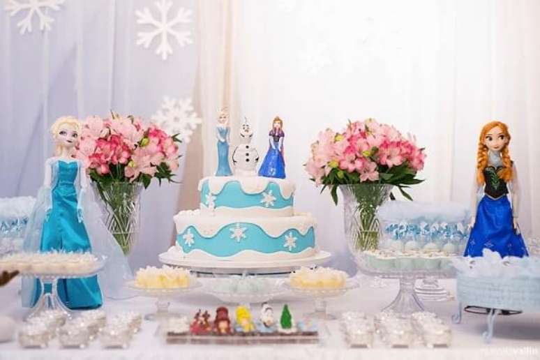 65- Na festa Frozen ideias criativas o bolo azul tem as personagens enfeitando o topo. Fonte: Quintal aventura