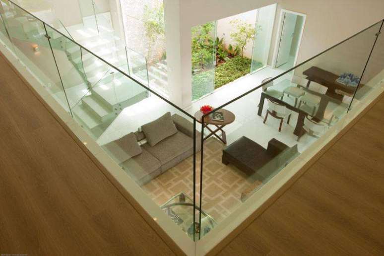 27. Ambiente de passagem para outros cômodos com piso elegante e vidro de proteção