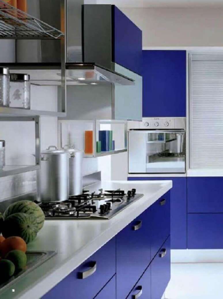 33. Modelo de armário de cozinha azul e branco com cooktop sobre a bancada – Foto: The Holk