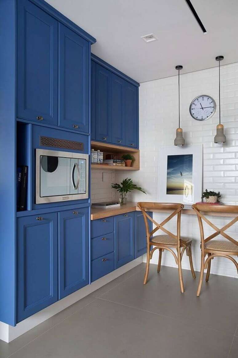 1. Decoração com modelo clássico de armário para cozinha azul com bancada de madeira – Foto: Pinterest