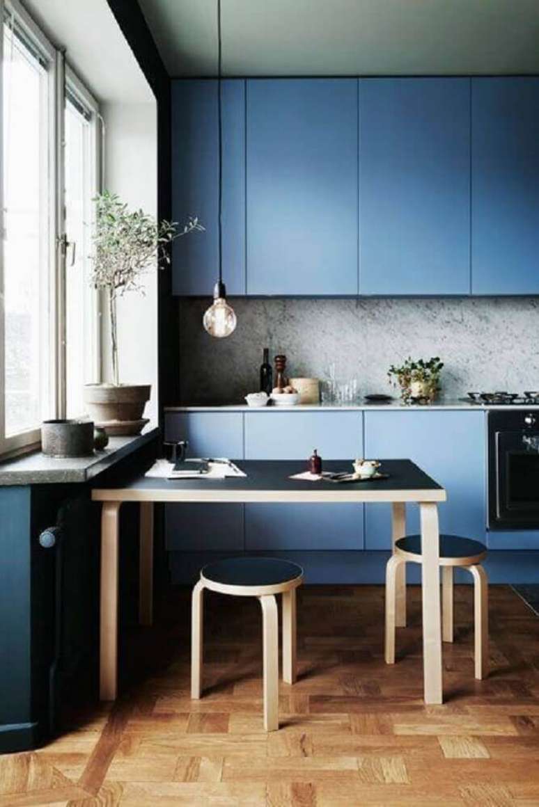 39. Decoração contemporânea para cozinha planejada azul com mesa de madeira e pendente minimalista – Foto: Virve