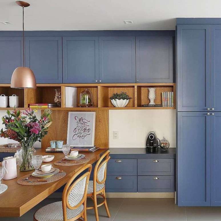 55. Os detalhes em madeira trazem aconchego para a decoração da cozinha azul – Foto: Pinterest