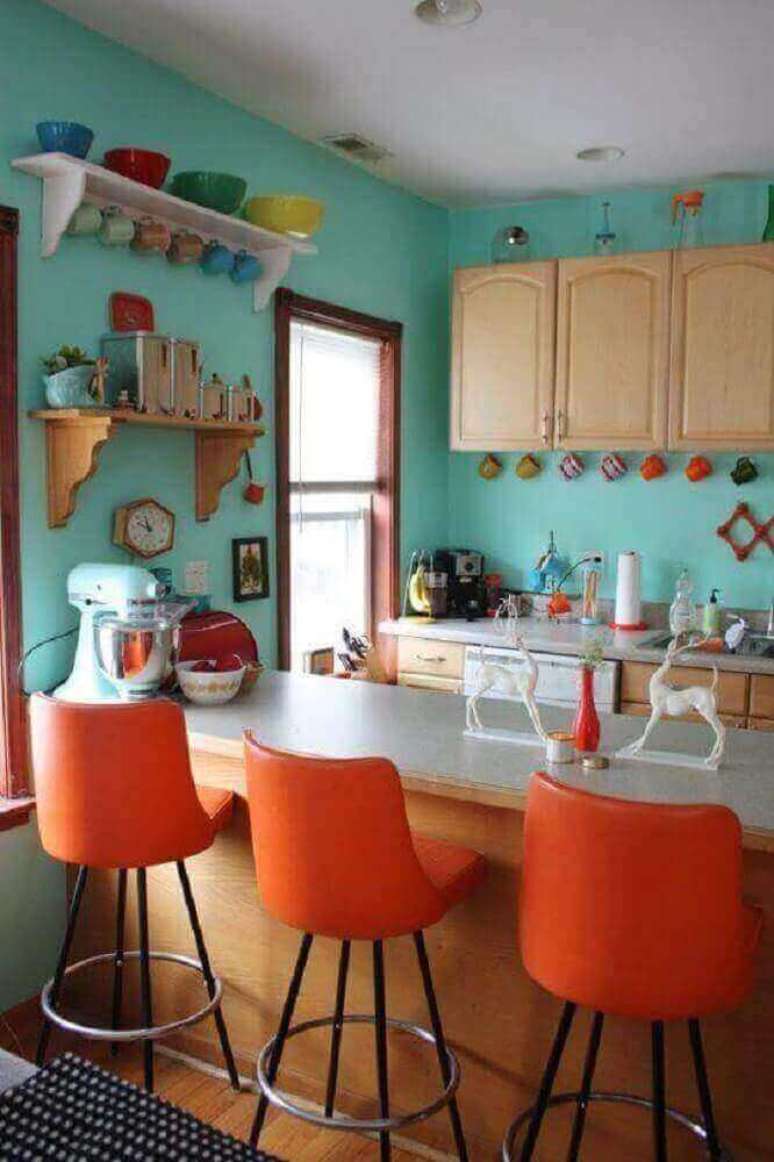 62. Decoração simples para cozinha azul turquesa com banquetas laranjas e armários de madeira – Foto: Home Design