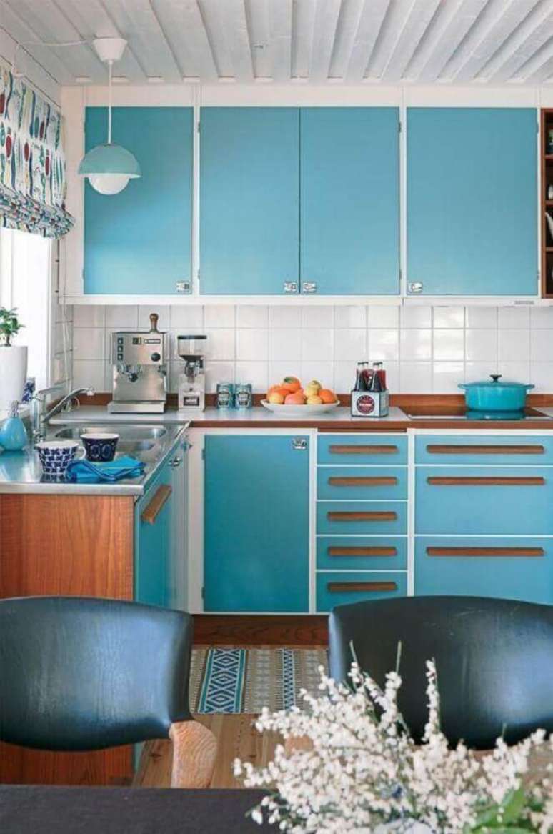 66. Decoração simples para cozinha azul turquesa com detalhes em branco e bancada de madeira – Foto: Utrails Home Design