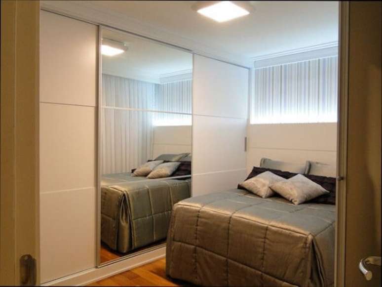 65- O guarda-roupa com porta de espelho decora o quarto em estilo moderno. Fonte: Casa e Festa