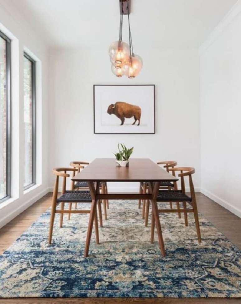 38. Decoração clean para sala de jantar com luminárias de teto e grande tapete azul – Foto: Pinterest
