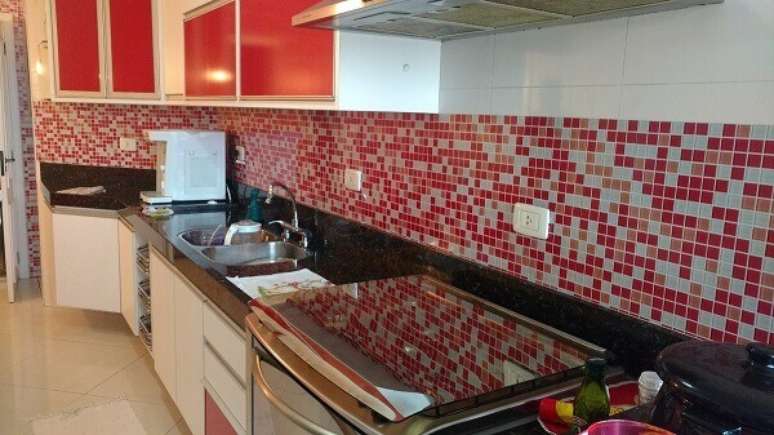 53. As pastilhas para cozinha mescladas em vermelho combinam com as portas dos arm&aacute;rios. Fonte: Theholk