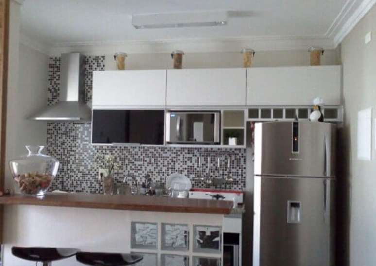 56. No ambiente integrado as pastilhas para cozinha revestem as paredes. Fonte: Transforme sua casa