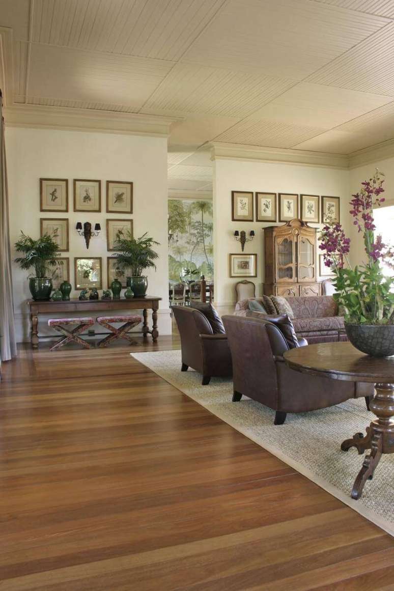 45. Sala de estar aconchegante com piso de madeira e tapete grande. Projeto de Roberto Migotto