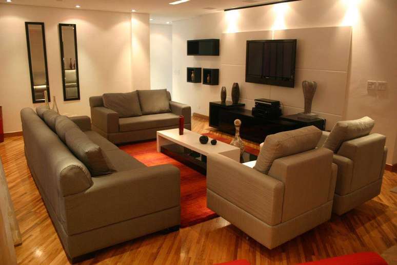 48. Sala de TV com iluminação confortável e piso de madeira. Projeto de Sueli Porwjan