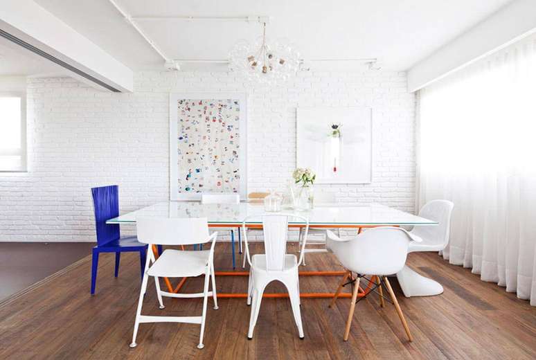 50. Sala de jantar moderna com cadeiras diferentes e assoalho de madeira. Projeto de Flávia Gerab Tayar