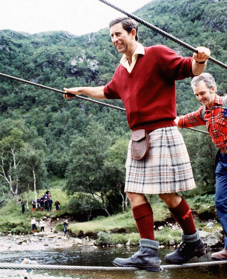 O pr&iacute;ncipe Charles atravessa ponte em meio a trilha nos arredores da montanha Ben Nevis, na Esc&oacute;cia