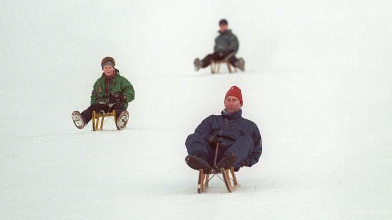 O pr&iacute;ncipe de Gales &agrave; frente dos dois filhos em brincadeira com tobog&atilde; na neve na Su&iacute;&ccedil;a