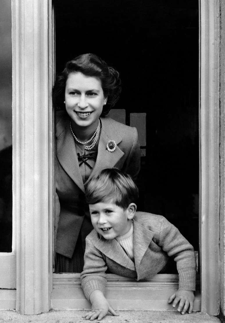 Prince Charles com a m&atilde;e, j&aacute; coroada rainha, no ano de seu quarto anivers&aacute;rio