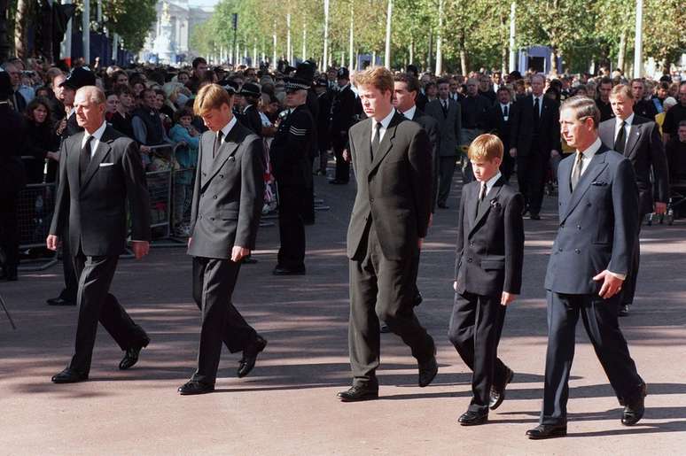 O duque de Edimburgo, o pr&iacute;ncipe William, o conde Spencer, o pr&iacute;ncipe Harry e o pr&iacute;ncipe de Gales acompanham a prociss&atilde;o funeral da princesa Diana; ap&oacute;s a morte dela, Charles insistiu que ela recebesse uma homenagem com honraria real