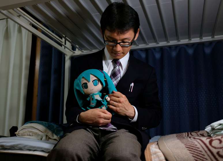 Akihiko Kondo posa para foto com boneca baseada no holograma Hatsune Miku em Tóquio, no Japão 