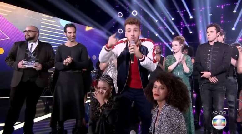 Jo&atilde;o C&ocirc;rtes agradece a produ&ccedil;&atilde;o do 'Popstar' quando Ta&iacute;s Ara&uacute;jo estava prestes a falar com a campe&atilde; do programa, Jennifer Nascimento.