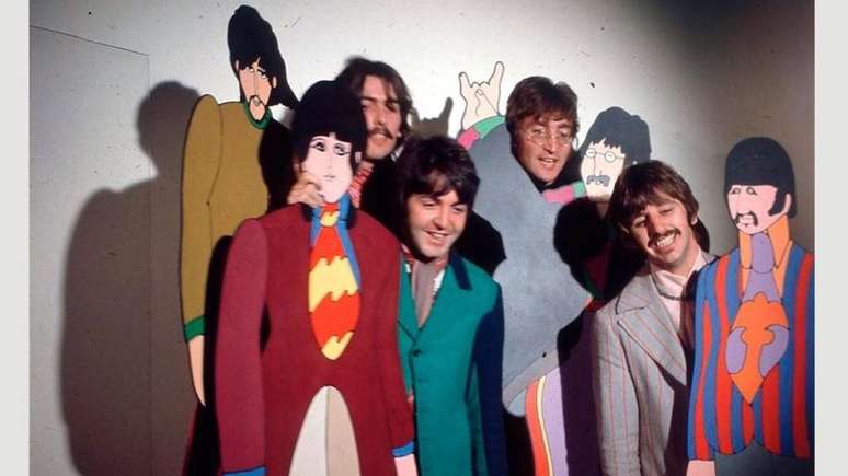 Integrantes dos Beatles posam com figuras do álbum Yellow Submarine characters em 1967 - seu estilo visual refletia o pico da era psicodélica