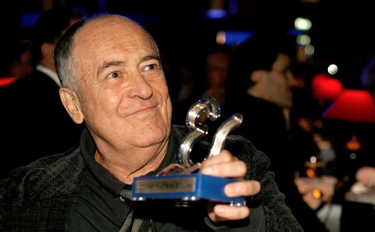 Bertolucci segura troféu de homenagem que recebeu no festival de Estoril