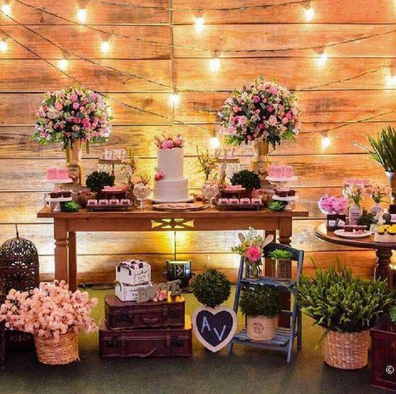 1. Mesa de chá de panela com decoração rústica e muitos arranjos de flores
