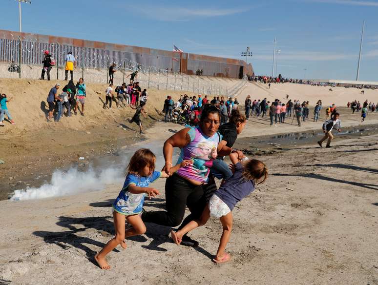 Família de imigrantes escapa de bombas de gás lacrimogêneo na fronteira do México com os EUA 25/11/2018 REUTERS/Kim Kyung-Hoon