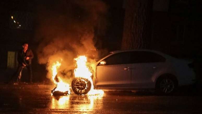 Um carro foi queimado durante protestos em frente à embaixada russa na capital ucraniana, Kiev, no domingo