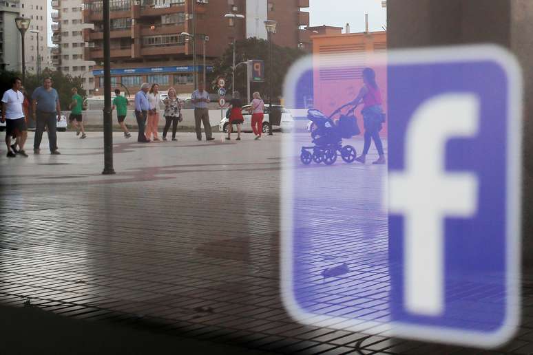 Logo do Facebook é visto refletido em vitrina de loja na Espanha. 4/06/2018. REUTERS/Jon Nazca.