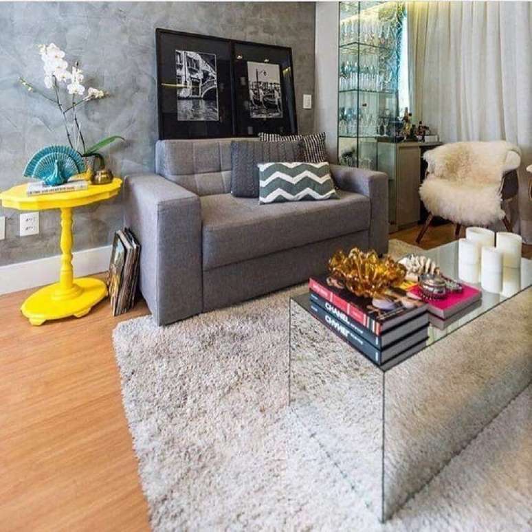 39. Modelo de sof&aacute; para sala pequena decorada com mesa de centro espelhada e parede de cimento queimado &ndash; Foto: Andrea de Paula e Gabriela N&oacute;brega