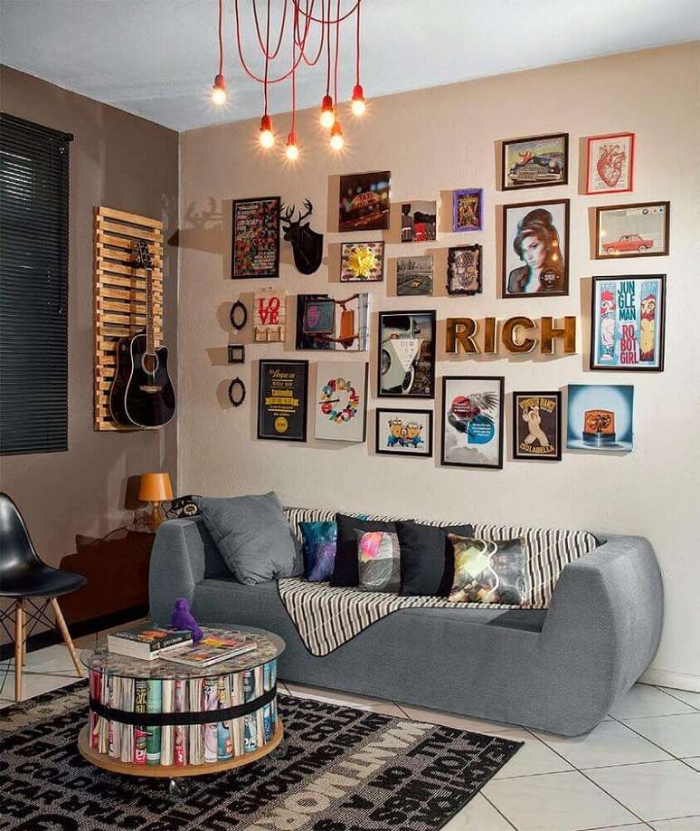 42. Modelo de sofá moderno para sala pequena decorada com muitos quadros e pendentes modernos vermelhos – Foto: Aaron Guides