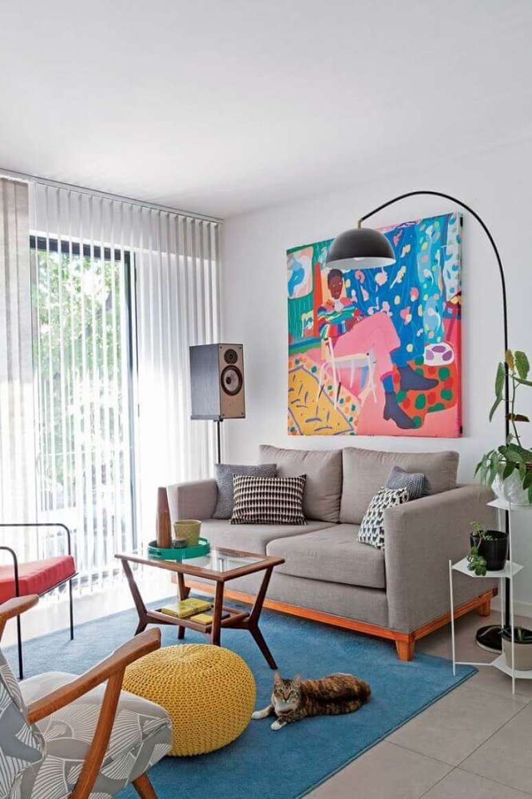 66. Decoração com sofá moderno para sala pequena com grande quadro colorido e luminária de chão – Foto: Pinterest