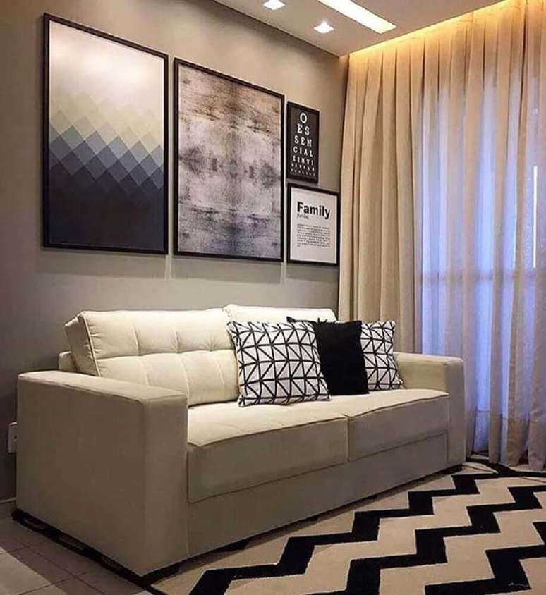 67. Sofá para sala pequena decorada com tapete preto e branco com estampa chanfrada e quadros grandes – Foto: Zozu