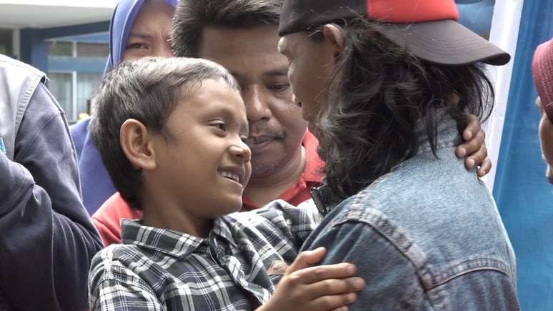 Fikri, que abra&ccedil;a o pai na foto, foi encontrado por uma estudante na beira de uma estrada