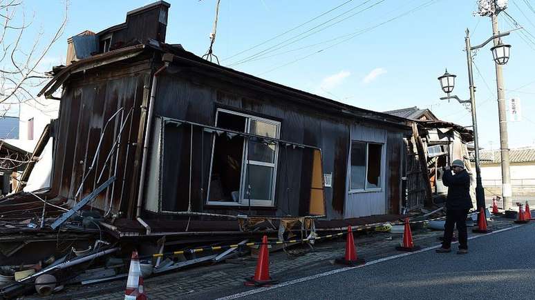 Em Fukushima, no Japão, onde o tsunami provocou a morte de 19 mil pessoas, os turistas tiram fotos na frente de casas destruídas