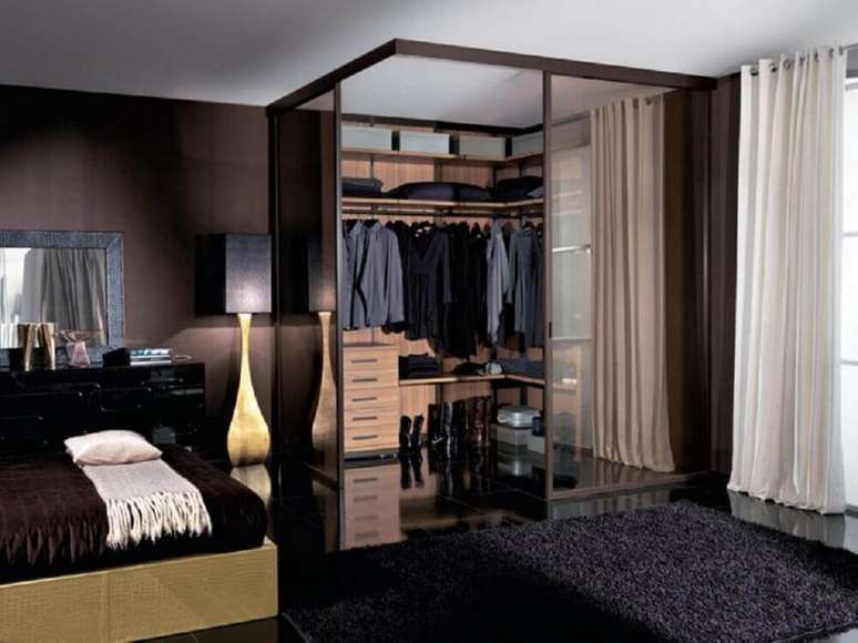 23. Decoração em tons escuros e acabamento em madeira para quarto com closet pequeno – Foto: Yandex